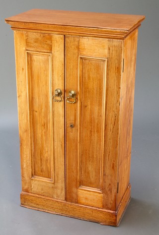 A cedar cigar cabinet, fitted shelves enclosed by a panelled door, raised on a platform base 34"h x 19 1/2" x 11"w  