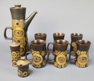 A 1970's Denby Arabesque coffee set comprising coffee pot and lid, 6 cups, a mustard pot and lid, salt shaker 