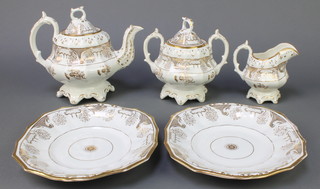A Victorian Rockingham style tea set comprising teapot and lid, milk jug, 2 handled sugar bowl and lid and 2 plates, having gilt and floral decoration 