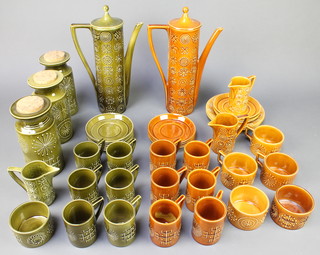 A Portmeirion Totem pattern green glaze coffee set comprising 6 coffee cups, 6 saucers, jug, sugar bowl, coffee pot and lid, 3 storage jars, a brown glazed ditto comprising 3 tea cups, 6 coffee cups, 2 sugar bowls, 2 milk jugs, a coffee pot and lid 4 small saucers, 3 large saucers and 3 plates 