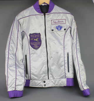 From the estate of Captain Eric M Brown, A 1978 British Helicopter Championship team silver bomber jacket, worn by Eric Brown as a judge and with embroidered badge Eric Brown 