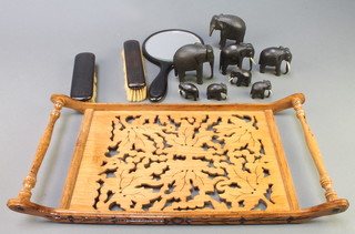 A 19th Century rectangular pierced wooden twin handled tray 19" x 9 1/2", an ebony 3 piece dressing table set comprising pair of clothes brushes, hand mirror and 9  various ebony elephants (1 f) 