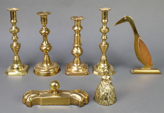 A 19th Century shaped brass paperweight 8", a pair of 19th Century brass candlesticks with knopped stems 10" (old solder repair), 2 other brass candlesticks 9 1/2", a copper and brass figure of a standing bird 9 1/2" and a brass table bell in the form of a crinoline lady 5" 