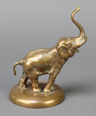 A gilt metal figure of a standing elephant with raised tusk 7" 