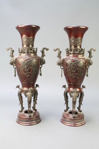 A pair of 19th Century Japanese bronze twin handled urns, the bodies decorated fabulous birds raised on griffin supports 18"