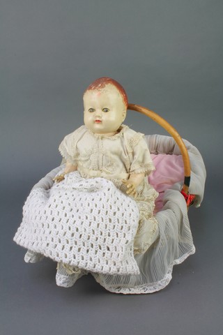 A plastic Pedigree doll with open and shutting eyes, contained in an oval wicker basket with bamboo handle (reputedly made by a German prisoner of war) together with a small card relating to the history of the doll  
