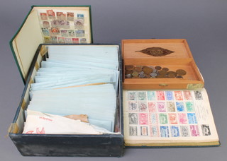 A collection of loose used World stamps, a green cardboard stamp album and various World stamps, a green stock of GB stamps and a small collection of coins 