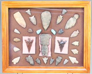 A collection of 27  native American Indian artefacts together with a carved stone figure of a Deity contained within a frame, the reverse marked George C Nickolas  and with newspaper clipping 11" x 14"