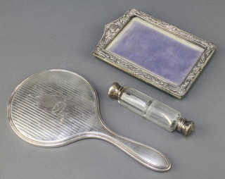 An Edwardian repousse silver photograph frame 7" x 5", a double ended scent bottle and a hand mirror