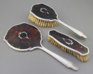 A silver and tortoiseshell pique brush set comprising hand mirror, hair brush and clothes brush, Birmingham 1932/1933 