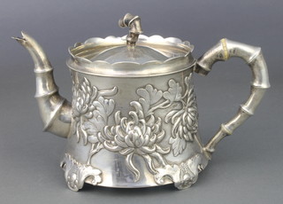 An early 20th Century Chinese cast silver teapot with faux bamboo handle, spout and finiial, the body decorated with flowering peony, 508 grams