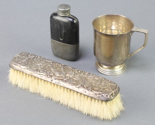 A silver mug Birmingham 1921, 110 grams, a silver backed clothes brush and a hip flask 