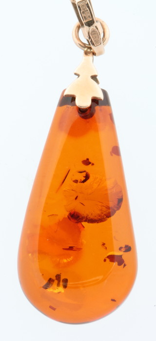A Russian yellow gold mounted amber pendant and chain 