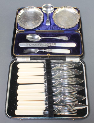 A Georgian III silver caddy spoon of simple form, a pair of 800 dishes, a cased plated christening set and cased plated fish eaters 