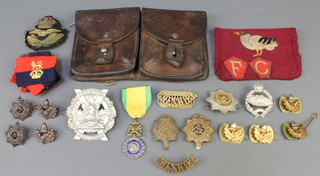 A leather 2 section ammunition pouch and minor cloth and metal badges etc 