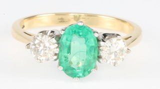 An 18ct yellow gold emerald and diamond ring, the centre emerald approx. 1.1ct flanked by 2 brilliant cut diamonds approx. 0.50ct, size M 1/2