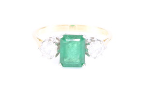 An 18ct yellow gold emerald and diamond ring, the centre emerald cut stone approx. 1.8ct flanked by 2 brilliant cut diamonds approx. 0.55ct size O 