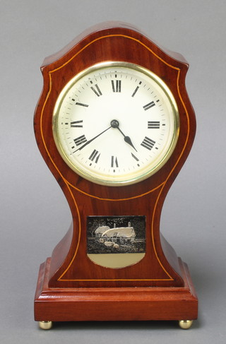 An Edwardian 8 day timepiece with enamelled dial and Roman numerals contained in a shaped inlaid mahogany case set a plaque in the form of a cottage, raised on bun feet 