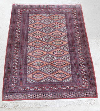 A red and peach ground Bokhara rug with 14 stylised octagons to the centre within a multi row border 74" x 54" 