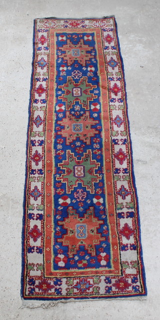 A blue ground Caucasian runner with 5 stylised medallions to the centre within multi row borders 94" x 28" 