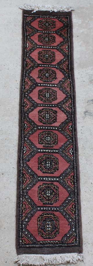 A pink ground Uzbek runner with 10 octagons to the centre 64" x 12 1/2" 