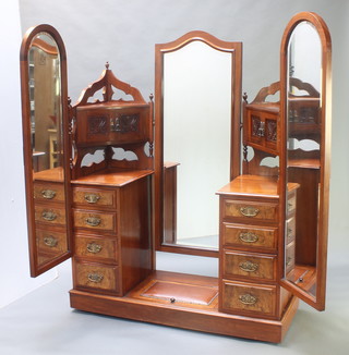 A Victorian walnut dressing table fitted an arched bevelled plate mirror flanked by a pair of double cupboards above 8 short drawers and flanked by a pair of arched bevelled plate mirrors, the base fitted a shoe box 67"h x 85"w x 22"d