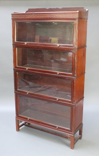 A 4 section mahogany Globe Wernicke style bookcase with raised back and blind fretwork frieze, raised on square tapered supports 65"h x 34"w x 12"d, label to the interior Meovoto 