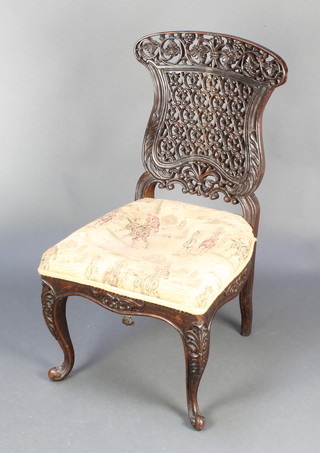A Victorian Anglo Indian carved and pierced hardwood slat back chair, the seat of serpentine outline raised on cabriole supports 