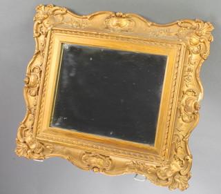 A 19th Century rectangular plate wall mirror contained in a decorative carved wooden and gilt plaster frame 14" x 16" 