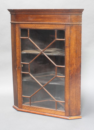 An 18th Century oak hanging corner cabinet with moulded cornice, fitted adjustable shelves enclosed by glazed panelled doors 39 1/2"h x 30"w x 16 1/2"d 