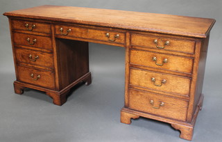 An oak dressing table/desk fitted 1 long drawer flanked by 8 short drawers with brass swan neck drop handles, raised on bracket feet 30"h x 65"w x 20"d 