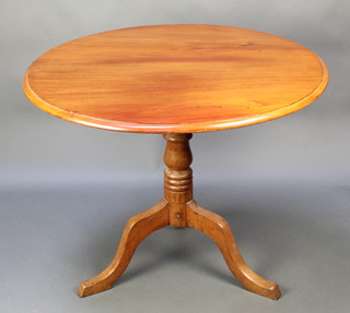 A 19th Century circular snap top tea table, raised on turned column and tripod base 27"h x 35" diam. 