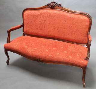 A carved walnut show frame sofa with carved shell crest, raised on cabriole supports upholstered in orange material 