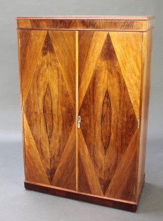 An Art Deco figured walnut gentleman's wardrobe with hinged rising lid and fitted interior, enclosed by panelled doors 55"h x 36 1/2"w x 18"d 