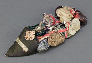 A 19th Century silk slipper containing various figures, marked There was an old woman who lived in a shoe ...  7 1/2" 