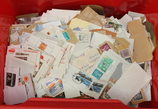 A red plastic crate of loose GB and World stamps 