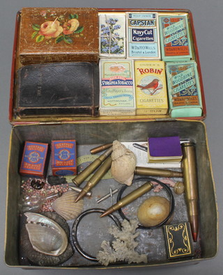 A metal tin containing a collection of cigarette cards, a leather bound Holy Bible, various fossils and curios 