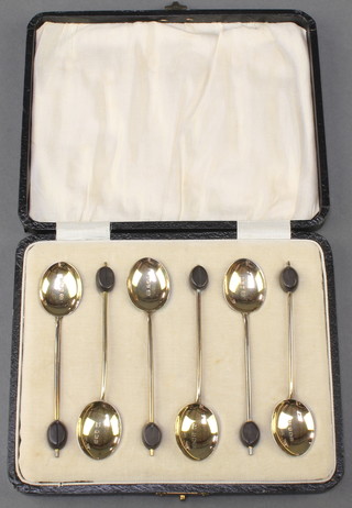 A set of 6 silver and enamelled bean end coffee spoons, Birmingham 1928 contained in a fitted leather case 