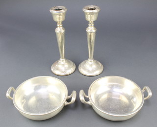 A pair of silver tapered candlesticks with weighted bases, Birmingham 1975 8 1/4" together with a pair of silver plated 2 handled bowls 