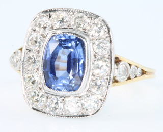 An 18ct yellow gold sapphire and diamond ring, the cushion cut centre stone approx. 1.90ct surrounded by 14 brilliant cut diamonds approx 0.80ct, size O 1/2 