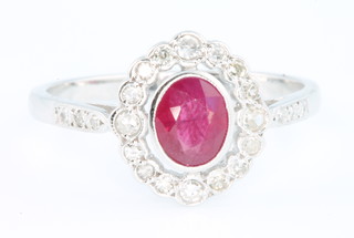 An 18ct white gold ruby and diamond oval cluster ring, size P
