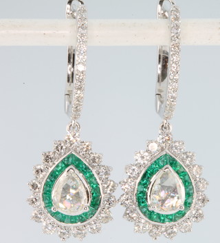 A pair of 18ct white gold pear cut emerald and diamond drop earrings, the emeralds approx. 1.22ct, the diamonds approx. 1.25ct 