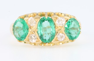 An 18ct yellow gold emerald and diamond ring size O 