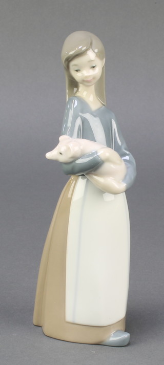 A Lladro figure of a girl cradling a pig 1011, 7" 