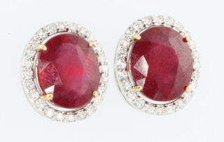 A pair of 18ct white gold oval ruby and diamond cluster ear studs 
