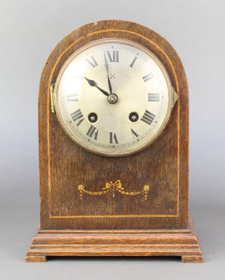 Hamburg American Clock Co., a striking mantel clock with silvered dial and Roman numerals contained in an arched oak shaped case 