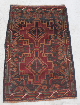 A tan ground Balochi rug with 2 stylised medallions to the centre 60" x 37" 