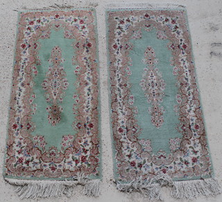 A pair of  Indian green ground and floral patterned hearth rugs 52" x 24" 
