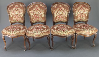 A set of 4 Victorian rosewood show frame dining chairs with upholstered seats and backs, the seats of serpentine outline, raised on cabriole supports  
