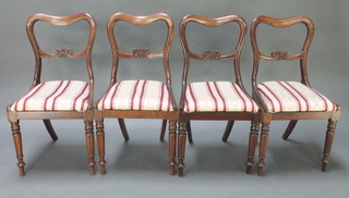 A set of 4 Victorian mahogany buckle back dining chairs with upholstered drop in seats, raised on turned supports 